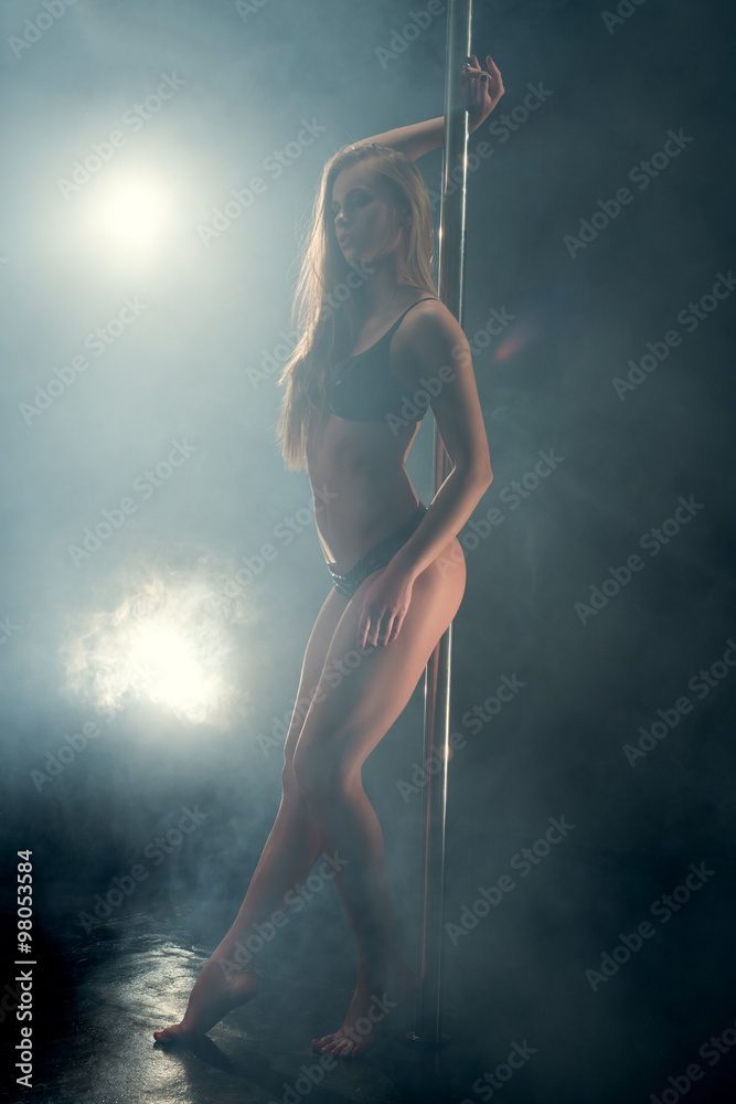 Erotica. Sexy girl dancing on pole in nightclub