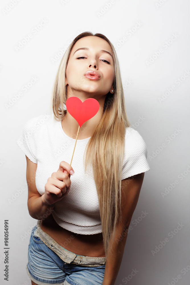 Playful young woman holding a party heart. Playful young woman holding a party heart.