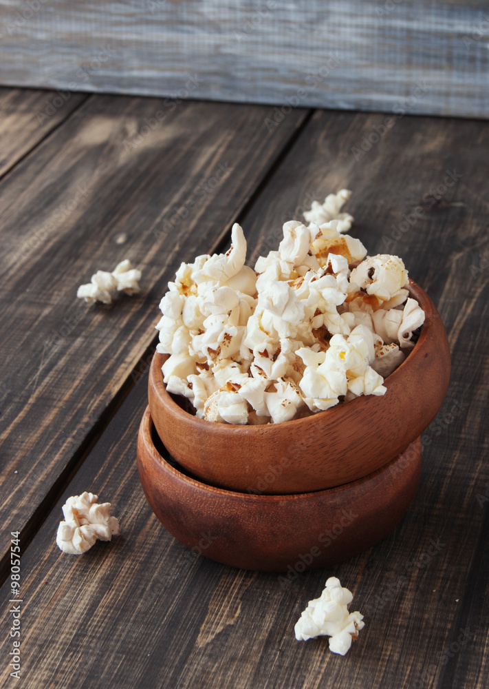 popcorn in wooden bowl on a wood background, selective focus popcorn in wooden bowl on a wood background, selective focus