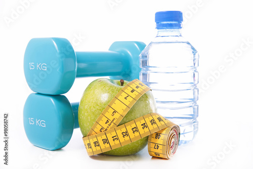 dumbbell and apple with measuring tape