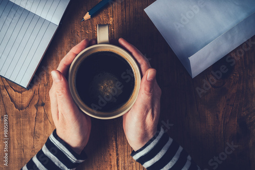Woman drinking coffee and writing letters