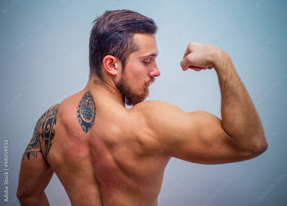 young and fit male model posing his muscles young and fit male model posing his muscles
