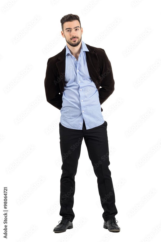 Fototapeta premium Young man in corduroy jacket posing with hands behind looking at camera. Full body length portrait isolated over white studio background.