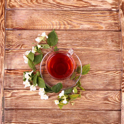 jasmine tea and jasmine flowers on wooden background, top view