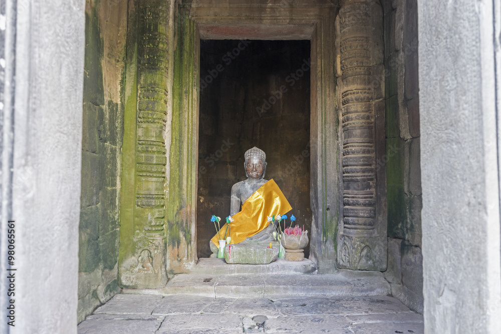 Obraz premium Buddha's statue between column of Angkor Wat