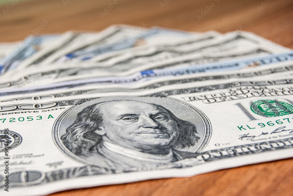 100 US dollars banknotes on wooden background 100 US dollars banknotes on wooden background