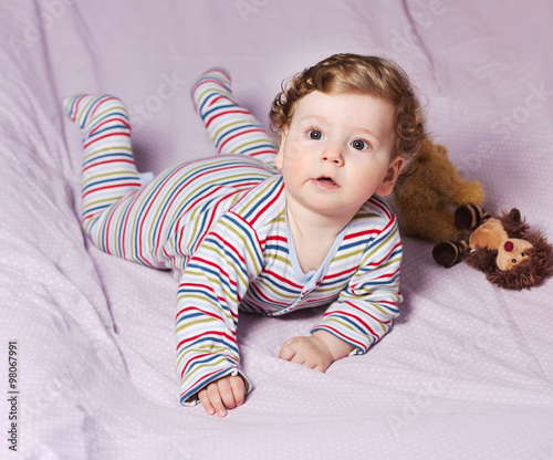 Beautiful baby with a lovely toy. The child in the crib. 