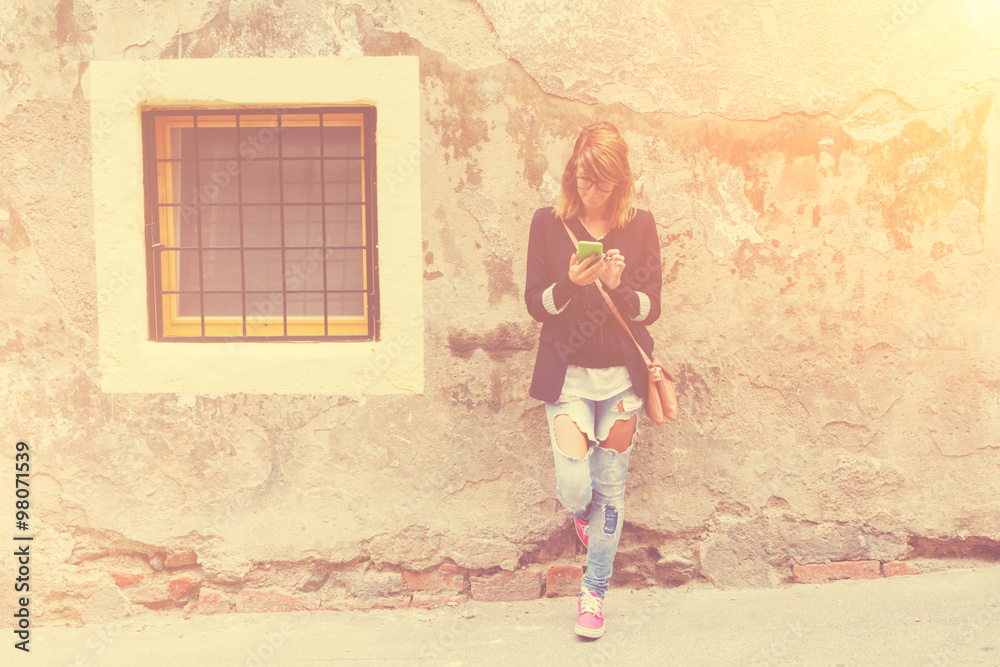 Girl typing messages on the street. Girl typing messages on the street.