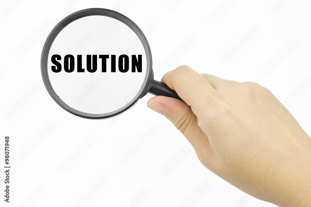 Hand showing SOLUTION word through magnifying glass Hand showing SOLUTION word through magnifying glass