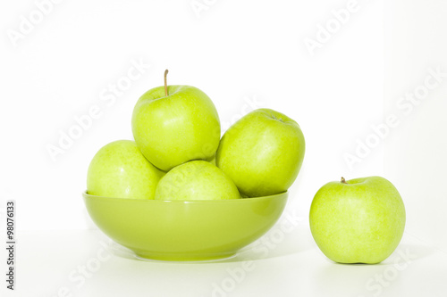 Green plate of fresh green apples isolated on white