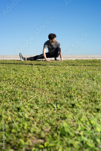 man stretches the leg in the ground space for text down photo