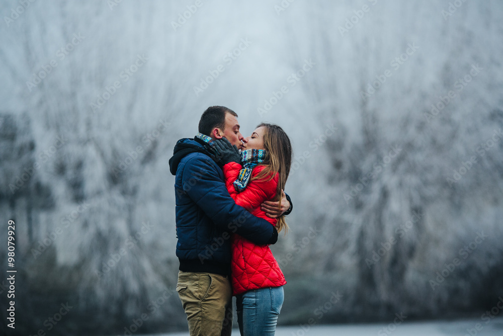 beautiful couple posing near a frozen river beautiful couple posing near a frozen river