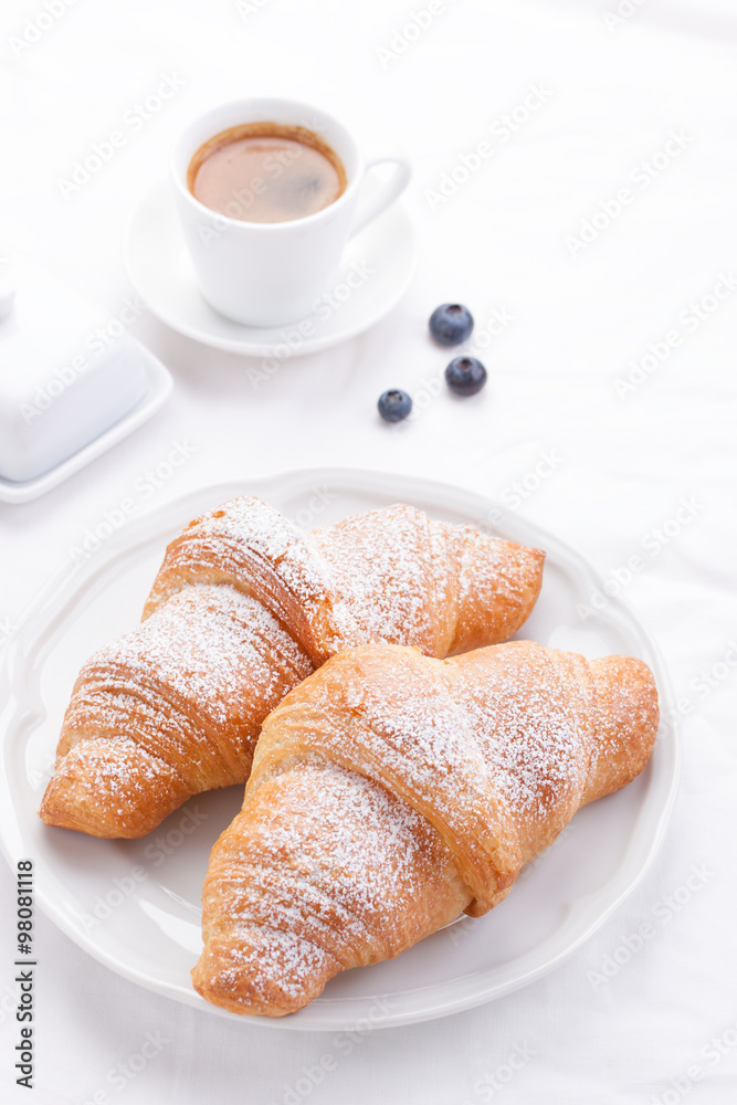 .Couple of croissants on a white plate with coffee and berries. selective focus.