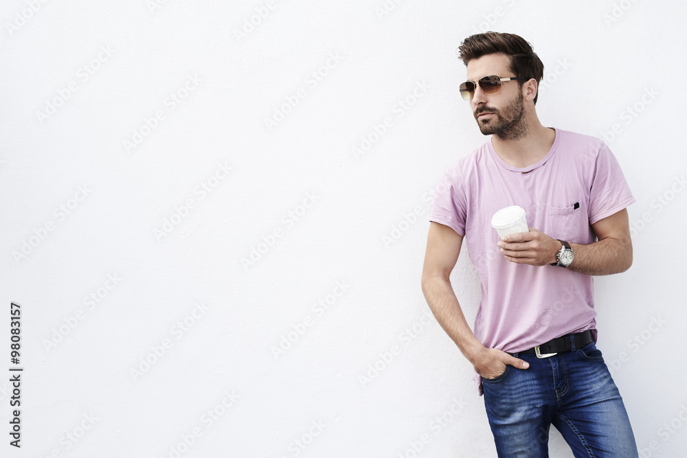 Young man posing against white wall, looking away Young man posing against white wall, looking away