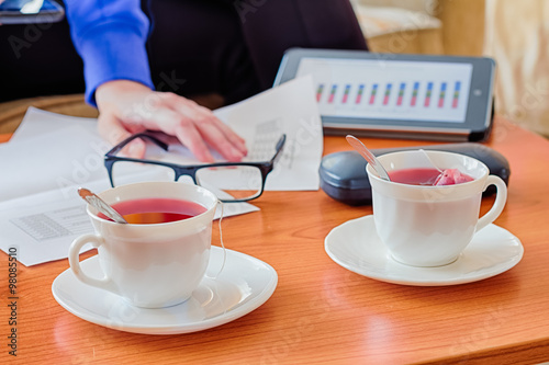 Business lunch on wooden table and cup of tea