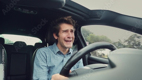Sad desperate man crying while driving car