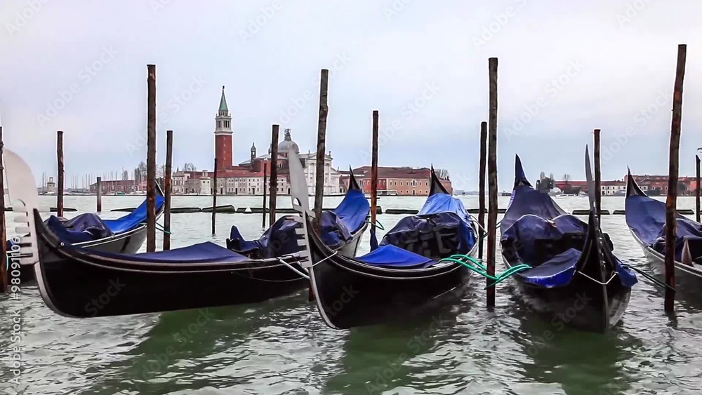 Quay at St Mark's Square with gondolas floating and the view to San Giorgio Maggiore Island in a cloudy spring afternoon. Quay at St Mark's Square with gondolas floating and the view to San Giorgio Maggiore Island in a cloudy spring afternoon.
