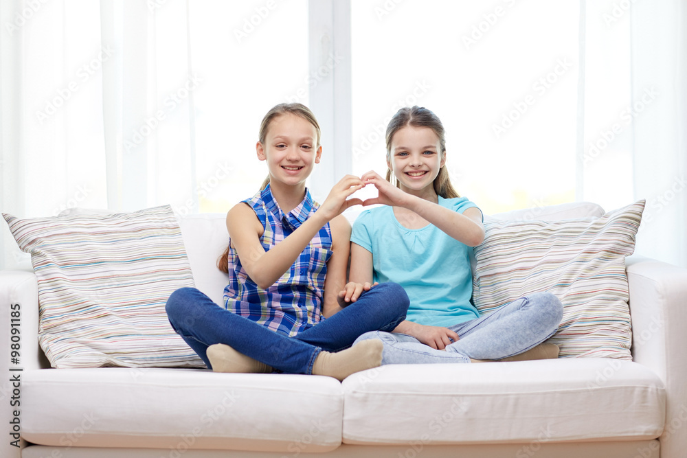 happy little girls showing heart shape hand sign
