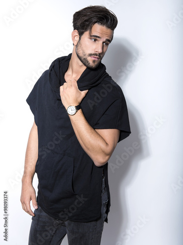 handsome and fit young man in casual outfit posing with wrist watch
