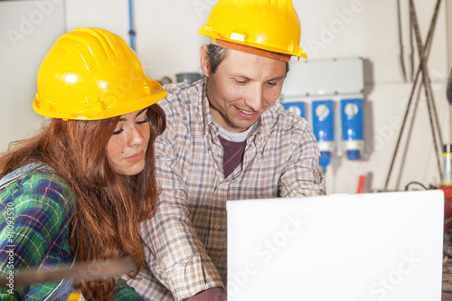 couple of engineers consult the computer in a steel mill