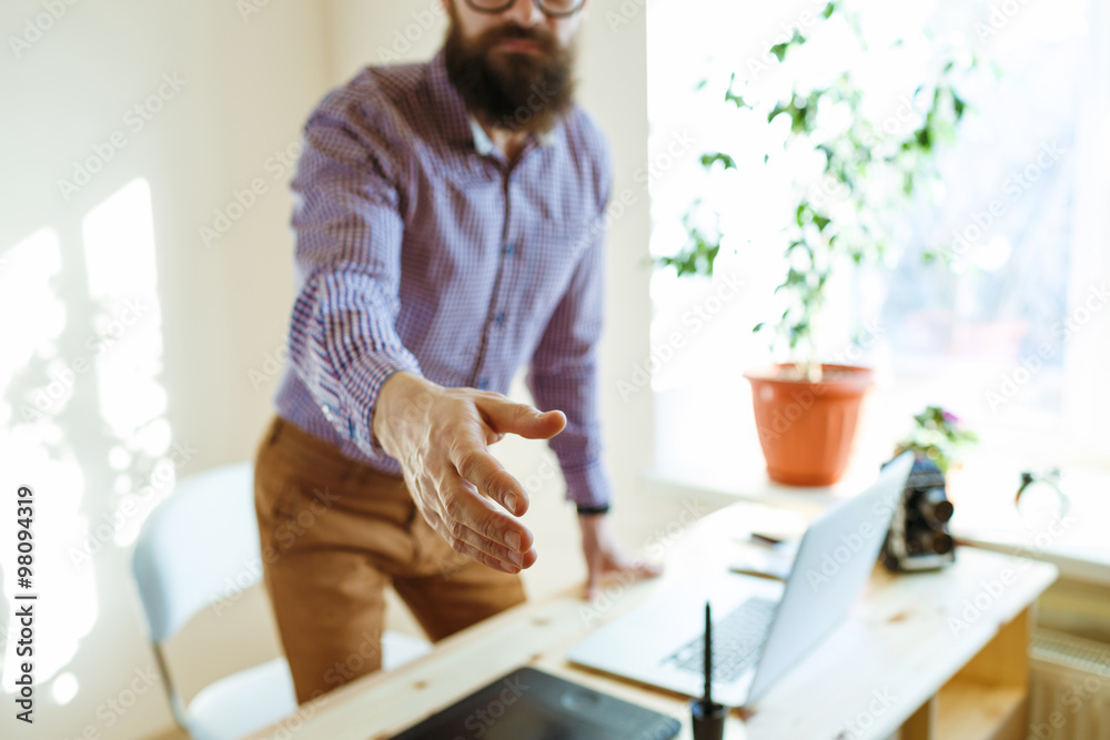 Business man with arm extended to handshake