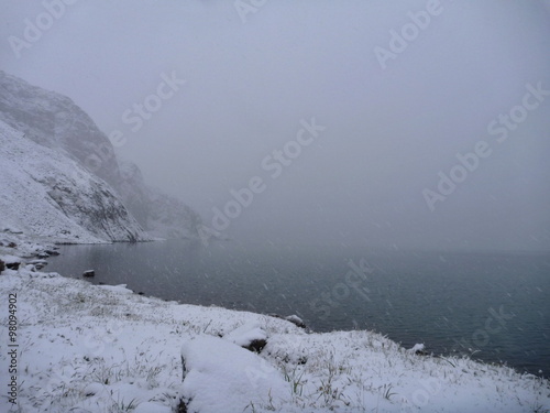 snowy morning at the lake shote in mountains