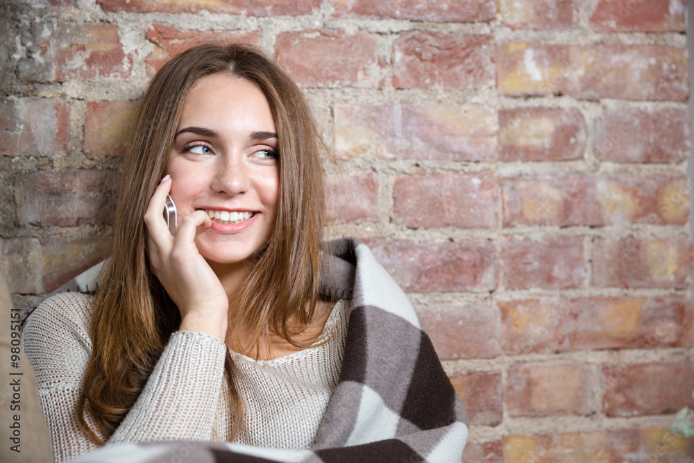 Smiling woman in warm plaid talking on the phone Smiling woman in warm plaid talking on the phone