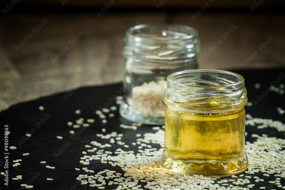 Sesame oil in the pot and sprinkled sesame seeds, selective focu Sesame oil in the pot and sprinkled sesame seeds, selective focu