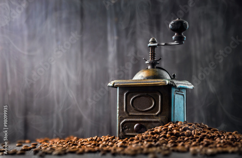 Antique vintage retro bronze coffee mill on black wooden board