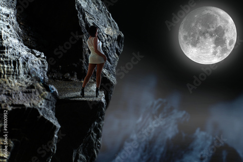 Piękna dziewczyna w górach przy księżycu.