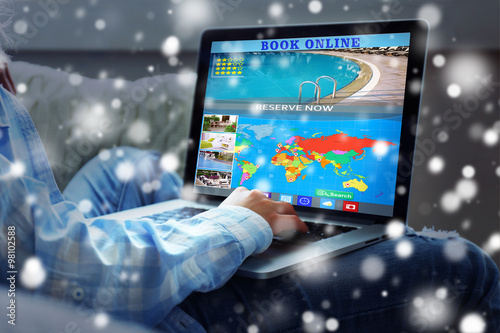 Human using laptop to book hotel online over snow effect
