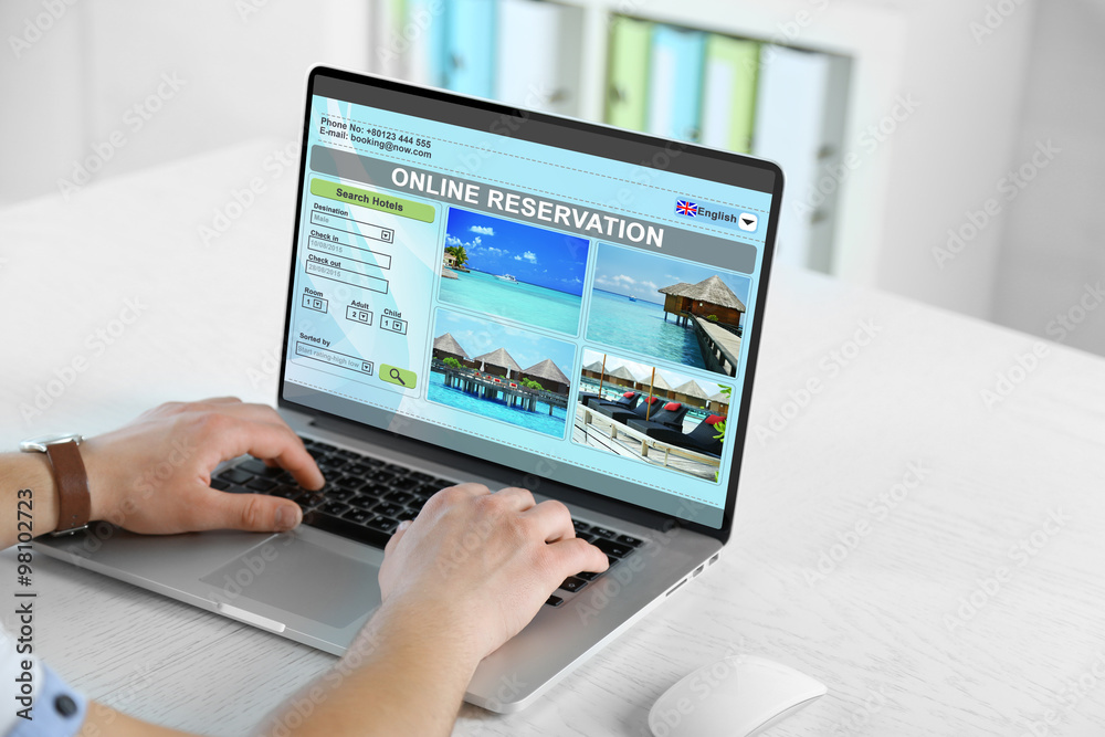 Man using laptop to book hotel online Man using laptop to book hotel online