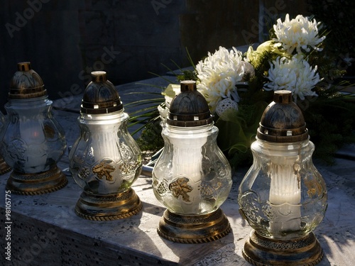 burning candles on tomb during All Souls' Day photo