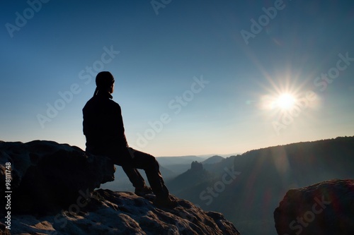 Tired hiker take a rest in nature. Mountain summit above forest in valley. Traveling in European natural parks.