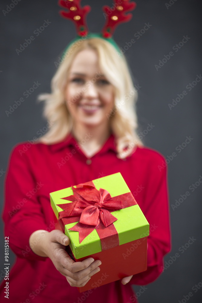 Happy smiling Santa girl with gift box enjoying falling snowflak