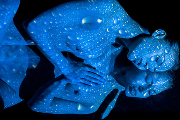 The body of woman with blue pattern and its reflection