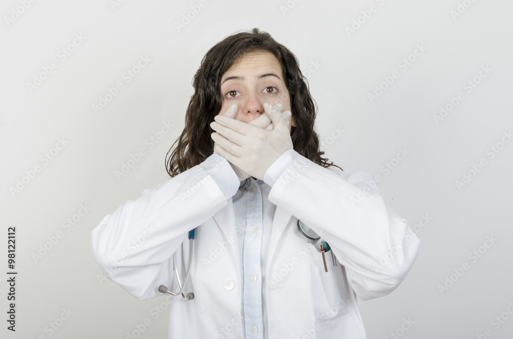 Female doctor covering her mouth with her hands. Female doctor covering her mouth with her hands.