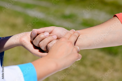 Closeup of nurse's hands checking someone's pulse in summer countryside © gorosi