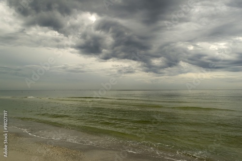 Tropical beach with shallow water and stormy dark sky