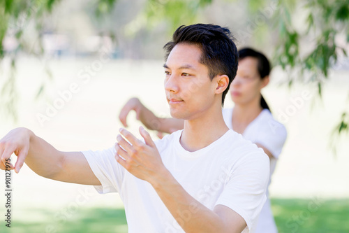 People practicing thai chi in park