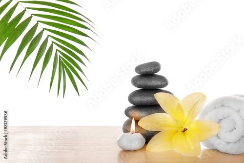 Spa stones with candle, towel and lily, isolated on white