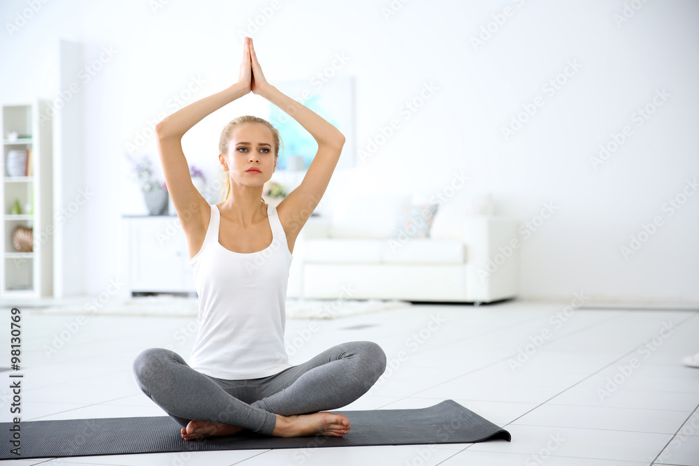 Young woman meditating in the room