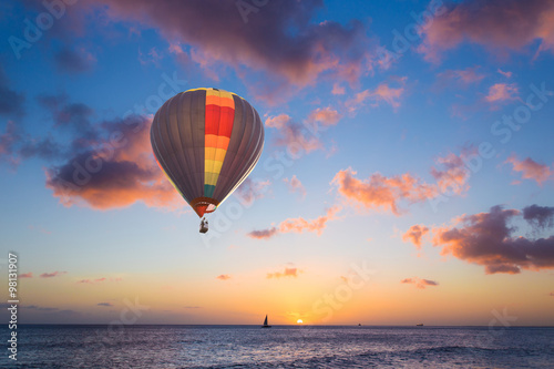 Hot air balloon over sunset sea