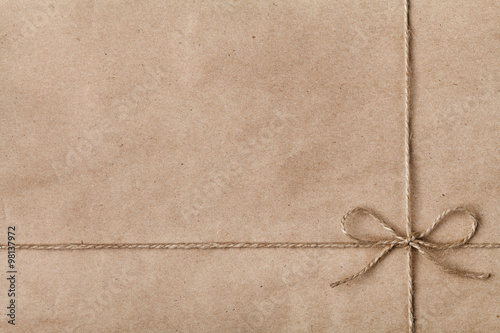 String or twine tied in a bow on kraft paper texture