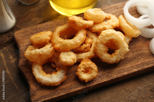 Chips rings with sauce and onion on cutting board
