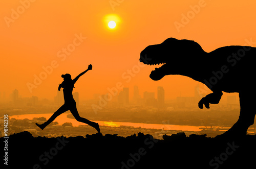 Fototapeta Naklejka Na Ścianę i Meble -  silhouette of woman run away from huge dinosaurs