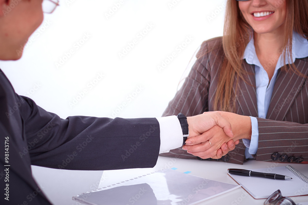 Business handshak sitting at the desk on office background, copy space area at the left upper corner Business handshak sitting at the desk on office background, copy space area at the left upper corner