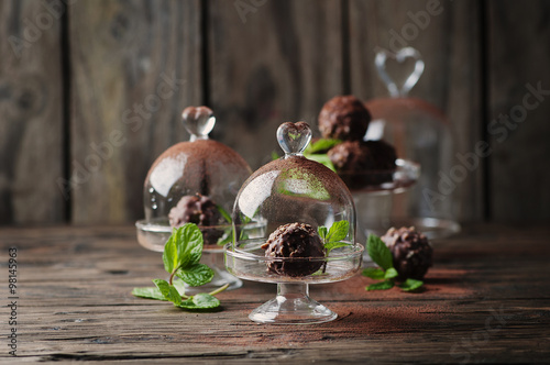 Chocolate sweets with nuts, mint and cacao on the vintage table