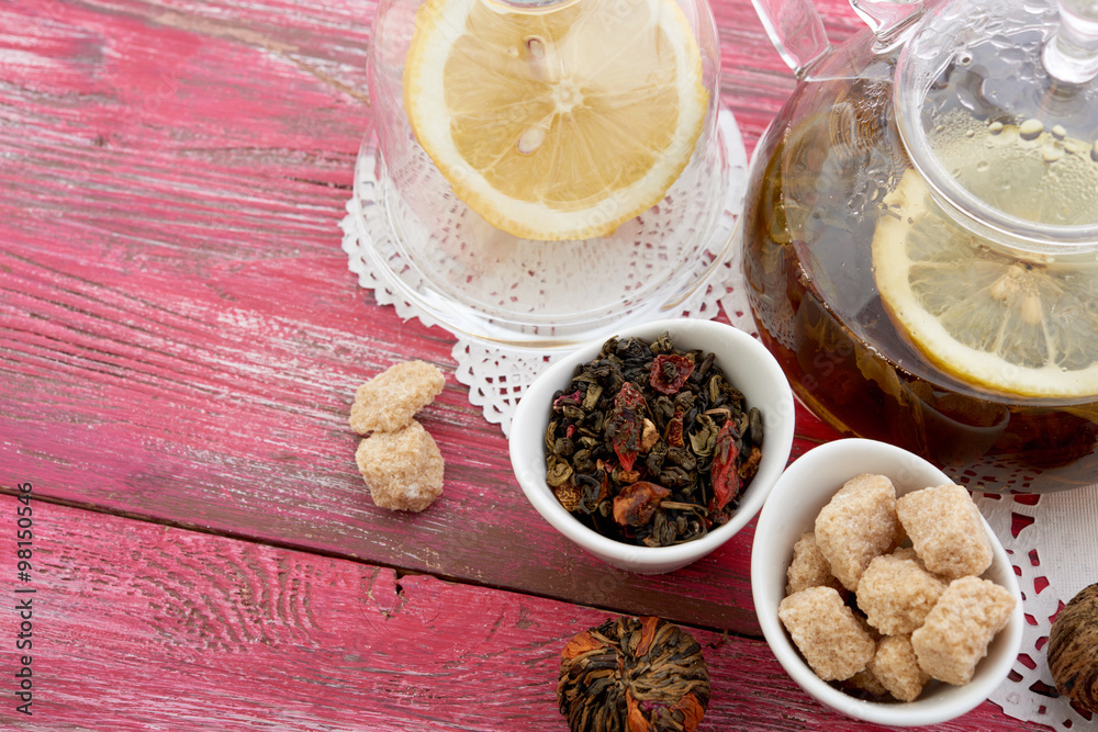 Ripe lemon, cinnamon and fruit drink in glass teapot on wooden background Ripe lemon, cinnamon and fruit drink in glass teapot on wooden background