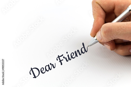 Hand writing "Dear Friend" on white sheet of paper.